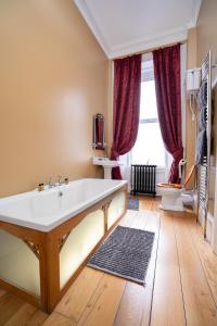 a bathroom with a large tub and a toilet at Antrim House Guest Rooms & Suites in Portrush