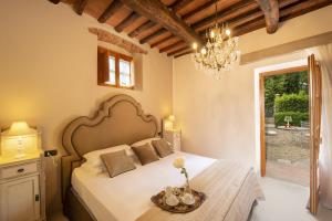 a bedroom with a bed and a chandelier at Villa Sempreverde - Homelike Villas in Greve in Chianti