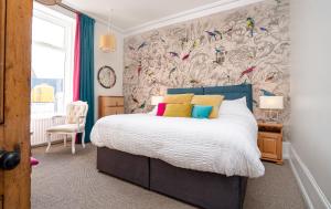 a bedroom with a bed and a wall with bird wallpaper at Antrim House Guest Rooms & Suites in Portrush