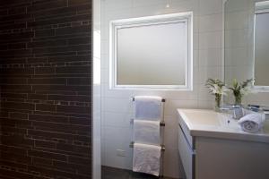 baño con lavabo y ventana en Casa Vista Apartment by Amazing Accom, en Queenstown