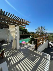 a patio with a pergola and a swimming pool at Casa Praia da Gamboa - Cabanas da Candoca, Vista para o mar in Garopaba