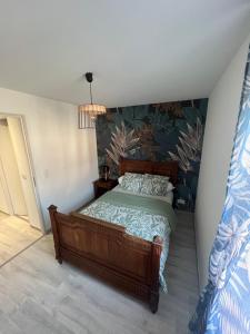 a bedroom with a bed in a room at Le Séjour qu'on M in Le Cateau