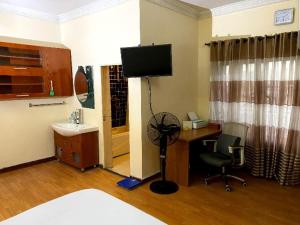 a room with a desk with a computer and a chair at Chez B&D Suites and Apartments in Abuja