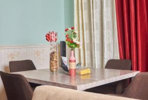 a table with vases and flowers on top of it at Chez B&D Suites and Apartments in Abuja