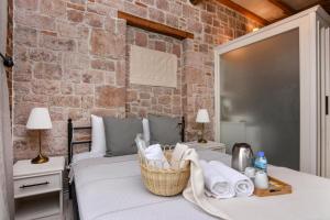 a bedroom with two beds and a brick wall at Lunaria Guest House in Ayvalık