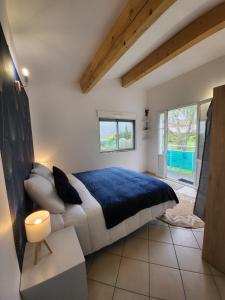 a bedroom with a large bed with a blue blanket at Nid douillet - LES FARGETTES - superbe vue - charmante petite maison avec jardin - 2 pièces à Privas in Privas