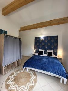 a bedroom with a bed with a blue comforter at Nid douillet - LES FARGETTES - superbe vue - charmante petite maison avec jardin - 2 pièces à Privas in Privas