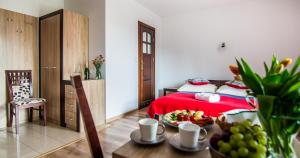 a bedroom with a red bed and a table with fruit at Willa U Zająców II in Zakopane