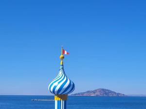 a blue and white striped pole in front of the ocean at Amantani palace in Ocosuyo