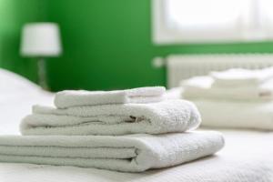 uma pilha de toalhas sentadas em cima de uma cama em Green House city center em Bolonha