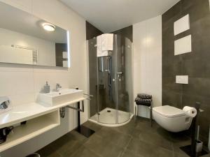 a bathroom with a sink and a toilet and a shower at Ferienwohnung Bertchen - barrierefrei mit Südterrasse und Carport in ruhiger Altstadtlage von Ballenstedt in Ballenstedt +30 photos