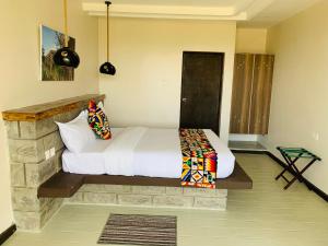 Outback Kenya Lodge في Machakos: غرفة نوم بسرير ابيض في غرفة