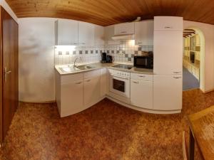 una cocina con armarios blancos y fregadero en Biohof Wallnerhof - Chiemgau Karte, en Inzell