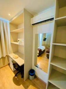 a room with a desk and a bed and a mirror at Coral Hotel - Próximo a PUCRS in Porto Alegre