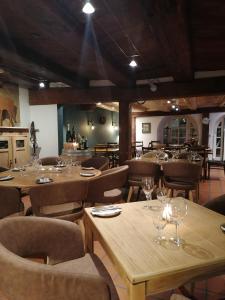 バート・ツルツァッハにあるGasthof zur Waagの木製のテーブルと椅子、ワイングラスのあるレストラン