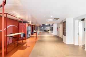 an office corridor with orange walls and stools at Camplus Regio Parco in Turin