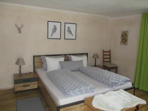 - une chambre avec un grand lit et des rideaux verts dans l'établissement Haus Schmauß - Chiemgau Karte, à Inzell