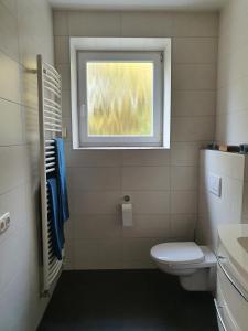 a bathroom with a toilet and a window at Belroki Ranch in Waldeck