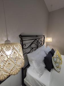 ein Schlafzimmer mit einem Bett mit weißen Kissen und einer Lampe in der Unterkunft Althea Apartments 3 in Chalki