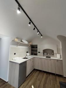 uma grande cozinha com paredes brancas e pisos de madeira em Althea Apartments 3 em Halki