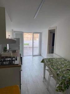 a kitchen with a stove and a table with a counter top at Appartamento sul mare Scoglitti 2 in Scoglitti