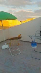 a patio with a table and an umbrella and a chair at Appartamento sul mare Scoglitti 2 in Scoglitti