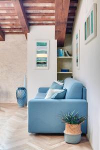 a blue couch in a living room with wooden ceilings at Rambaldi Apartments Casa nr 5 in Bardolino
