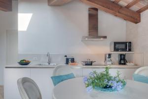 a kitchen with a table and chairs and a sink at Rambaldi Apartments Casa nr 5 in Bardolino