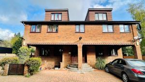 a brick house with a car parked in front of it at Sunshine Place St. Albans in Saint Albans