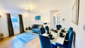 a dining room with a table and blue chairs at Sunshine Place St. Albans in Saint Albans