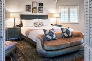 a bedroom with a bed and a leather chair at The Estate Yountville in Yountville