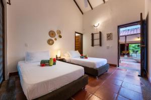 a bedroom with two beds and a window and a door at La Mello Adventure Lodge in Palomino