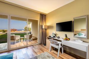 a hotel room with a desk and a television at Zen Resort Sahl Hasheesh by TBH Hotels in Hurghada