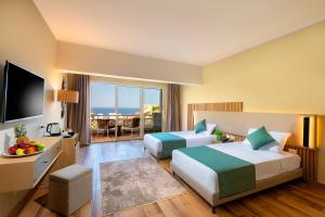 a hotel room with two beds and a television at Zen Resort Sahl Hasheesh by TBH Hotels in Hurghada