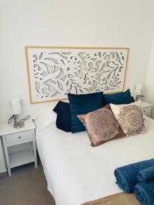 a bedroom with a white bed with pillows on it at Seafront La Manga Apartment in La Manga del Mar Menor
