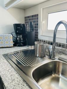 a kitchen sink with a pot on a stove at Seafront La Manga Apartment in La Manga del Mar Menor