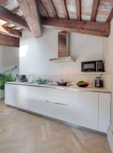 バルドリーノにあるRambaldi Apartments Casa nr 5の白いキャビネット付きのウッドフロアのキッチン
