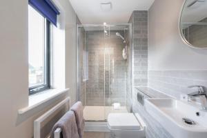 a bathroom with a shower and a toilet and a sink at Elliot Oliver - Luxurious Two Bedroom Apartment With Parking in Gloucester