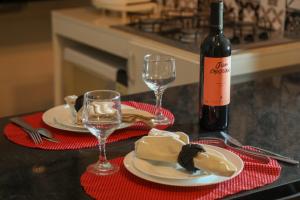 una mesa con dos copas y una botella de vino en Casa Pequena, Completa e Aconchegante - Tiny House en Palmas