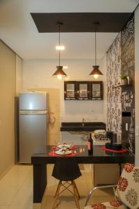 a kitchen with a refrigerator and a table in it at Casa Pequena, Completa e Aconchegante - Tiny House in Palmas