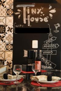 a table with two glasses and a bottle of wine at Casa Pequena, Completa e Aconchegante - Tiny House in Palmas