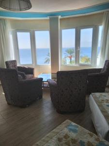 uma sala de estar com duas cadeiras e janelas com o oceano em Cender Hotel em Antalya