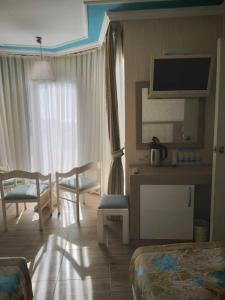 um quarto de hotel com uma cama e uma secretária com uma televisão em Cender Hotel em Antalya