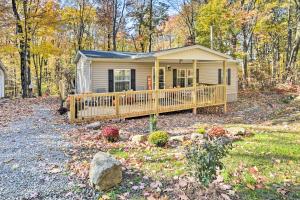 a tiny house in the woods with a porch at Charming Blue Knob Home Near Golfing and Skiing 
