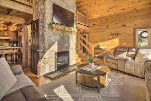 a living room with a stone fireplace in a log cabin at Beautiful Mount Joy Cabin with Pool and Sauna! in Mount Joy