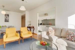 uma sala de estar com um sofá branco e cadeiras amarelas em Casa da Praça Apartments - by Casas na Ilha no Funchal