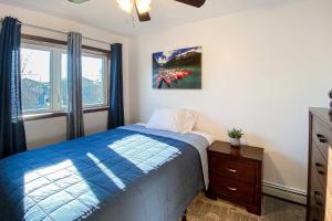 Un dormitorio con una cama azul y una ventana en Fairbanks Retreat with Massive Deck and Grill!, en Fairbanks