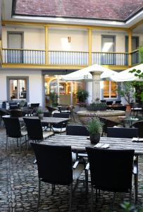 un restaurante al aire libre con mesas, sillas y sombrillas en Gasthof zur Waag, en Bad Zurzach