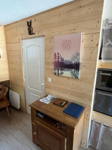 Habitación con pared de madera, mesa y puerta. en Babaute 7, studio typique au pied des pistes en Prémanon