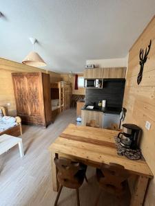 a kitchen with a wooden table in a room at Babaute 7, studio typique au pied des pistes in Prémanon